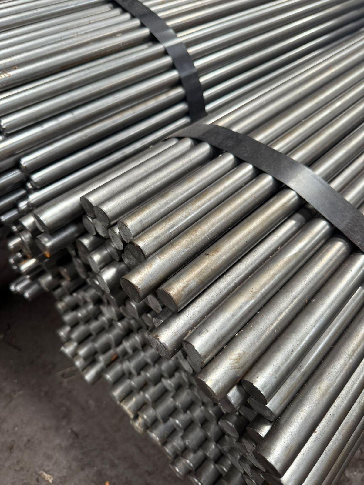 Close-up of a strapped bundle of cold-drawn bright round bars showing sheared ends and polished surface finish